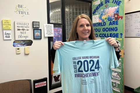  Kathy DeKeyser holding up a t-shirt for college bound students